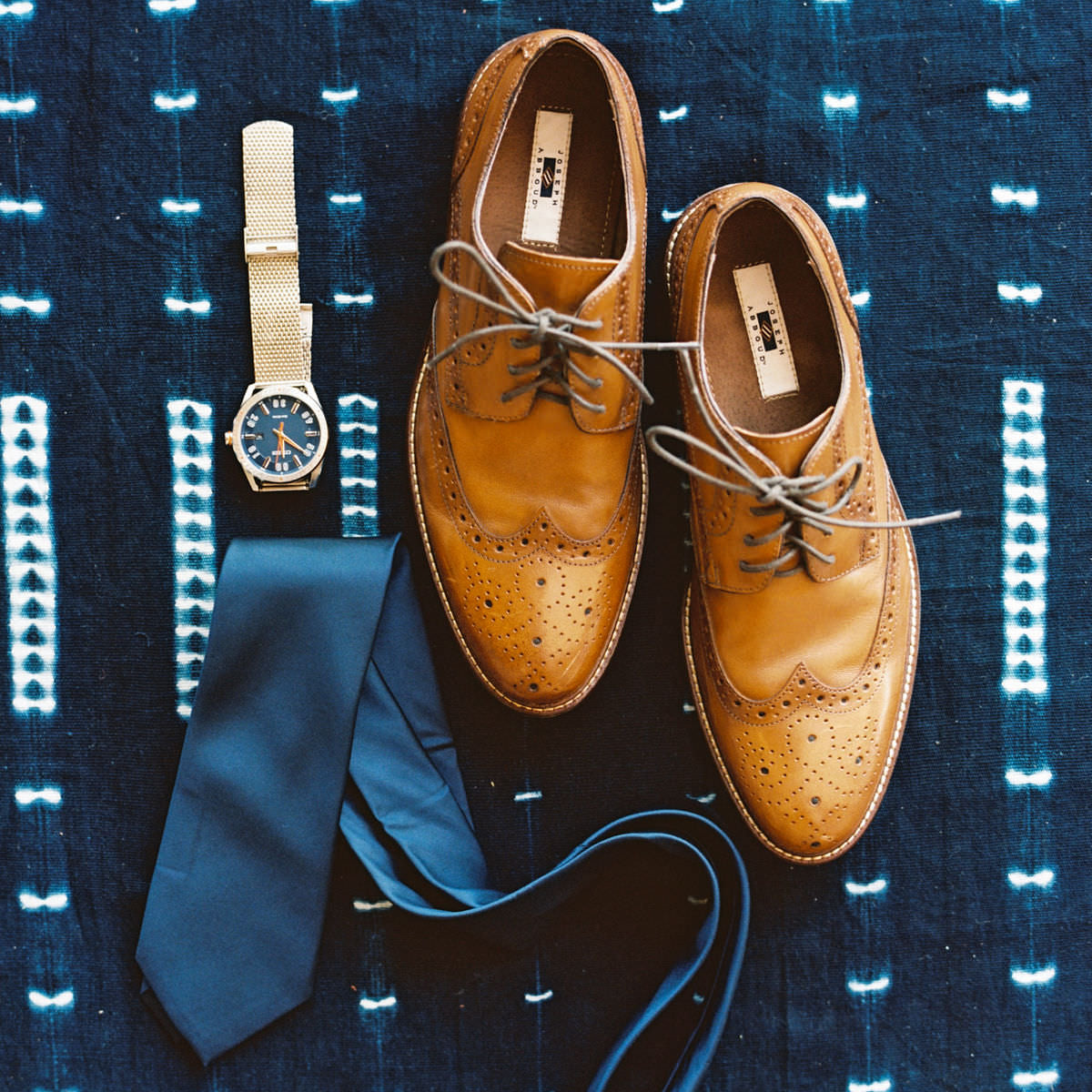 watch, tie and shoes in a flatlay