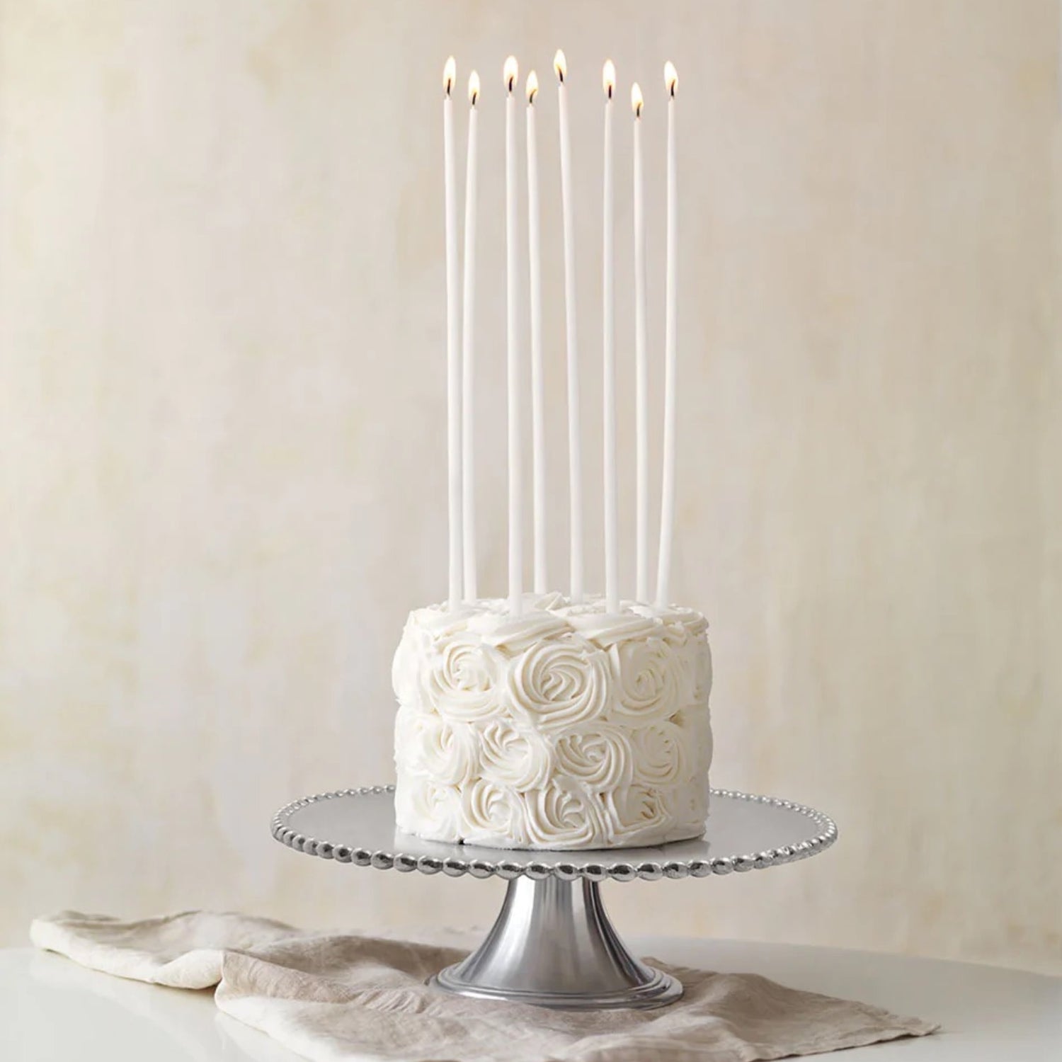 white cake with very long candles in it